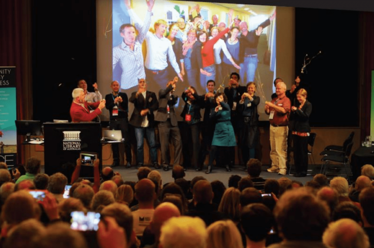 Group on stages at the Community Energy Congress popping streamers.