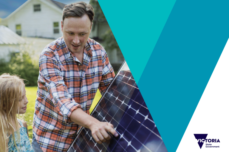 A man and young girl look at a solar panel up close.