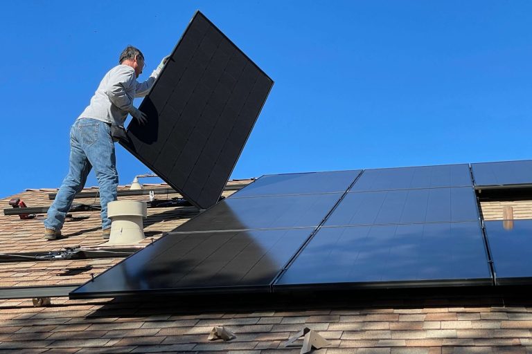 Worker installing solar panels on a roof
